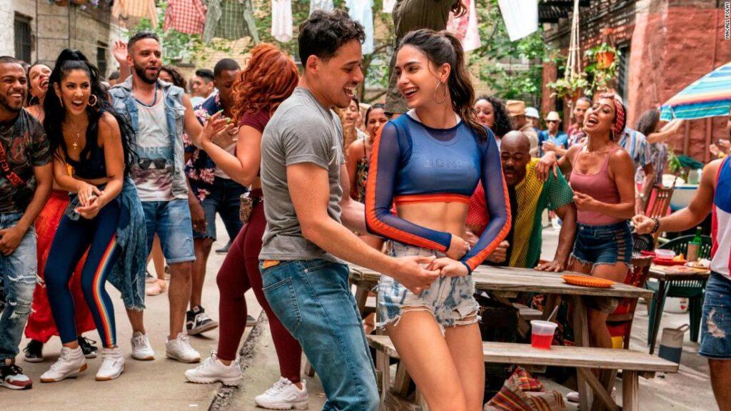 Vanessa and Usnavi dance and sing in “In the Heights” hit number “Carnaval del Barrio.” 