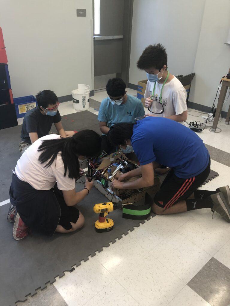 Rookie members of team MSET 6165 Cuttlefish work on the finishing touches of their robot together in the robotics room before their scrimmage.