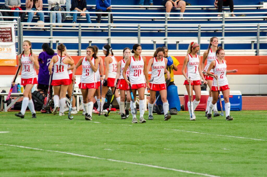 At the beginning of the game against Homestead, the field hockey team runs onto the field.
