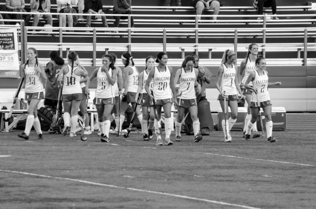 The field hockey team runs onto the field at the beginning of their game against Homestead.