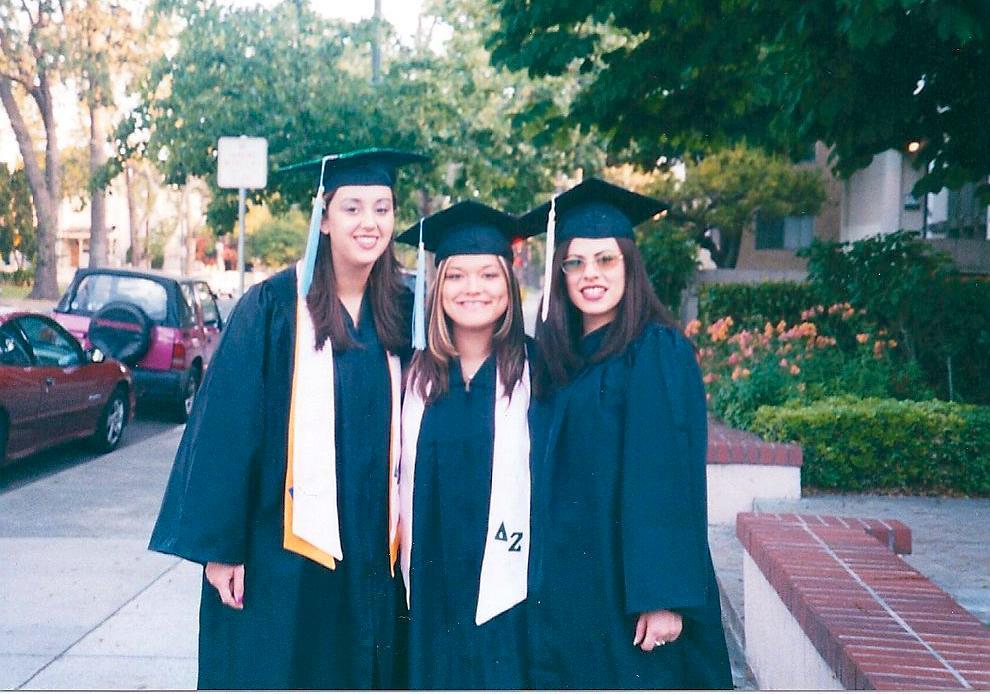 On her graduation day, Young stands in front of her sorority with two of her best friends.