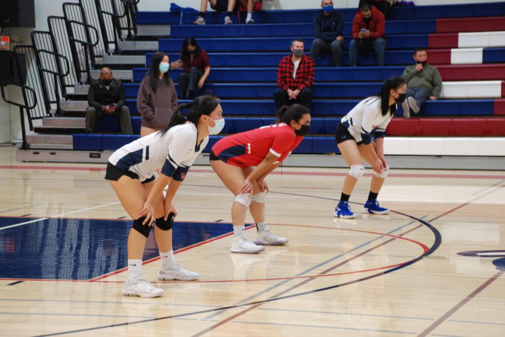 Emerson Pak getting ready to pass a serve along with upperclassmen Lisa Fung and Noor Khan.