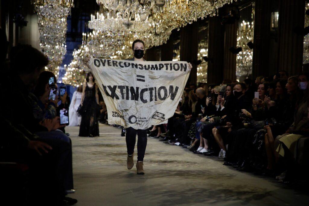 Activist Marie Cohuet crashed the Louis Vuitton show during Paris Fashion Week on Oct. 5 with a banner saying, “Overconsumption=Extinction,” to highlight the negative impacts of high fashion on the environment.