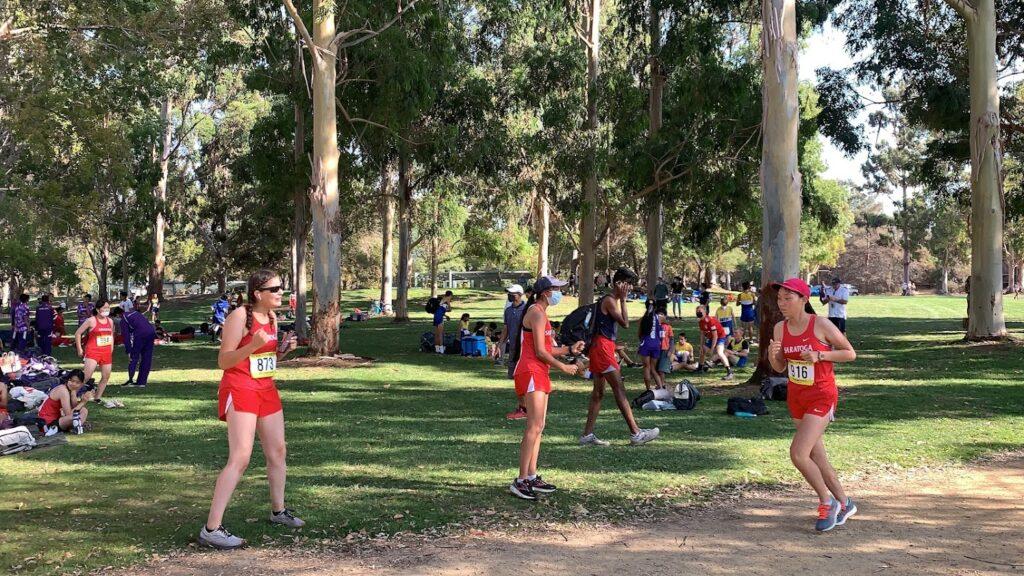 Juniors Irene Frazier and Maithili Kulkarni cheer on fellow teammate Carolyn Wang at Baylands Park on Sept. 21.