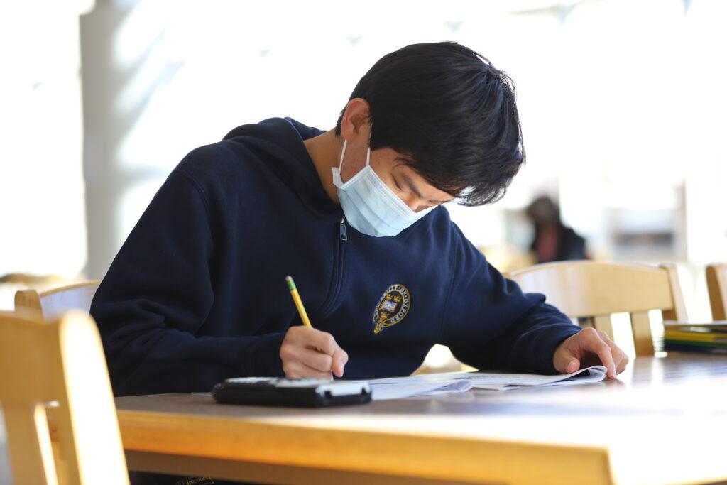 Senior Lance Wang looks over his answers for the SAT in the library on Oct. 28.