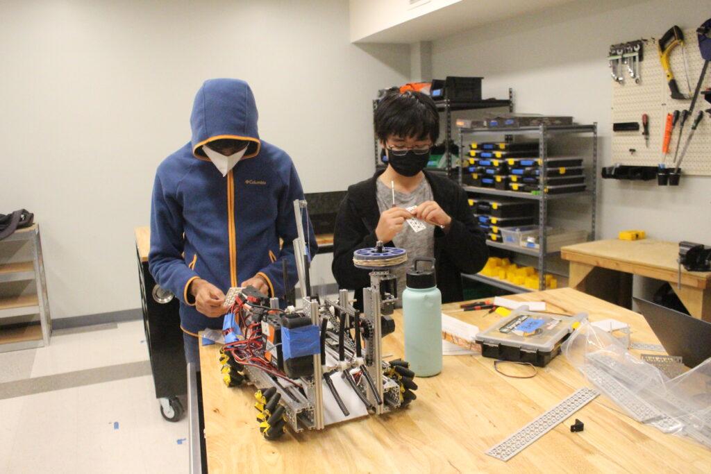 Sophomore Bettafish members Kai Otsuka and Rishab Melkote work on their robot in preparation for the scrimmage. 