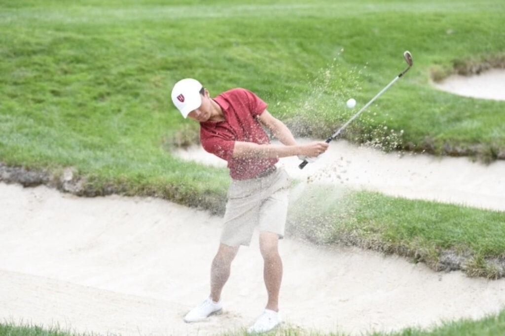 Harvard sophomore Kevin Sze plays a shot out of a bunker at The Country Club in Brookline, Massachusetts.