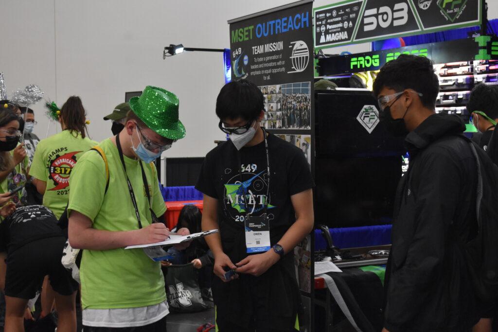 Sophomore Owen Liang answers questions for a scouter from another FRC team during the FRC World Championship