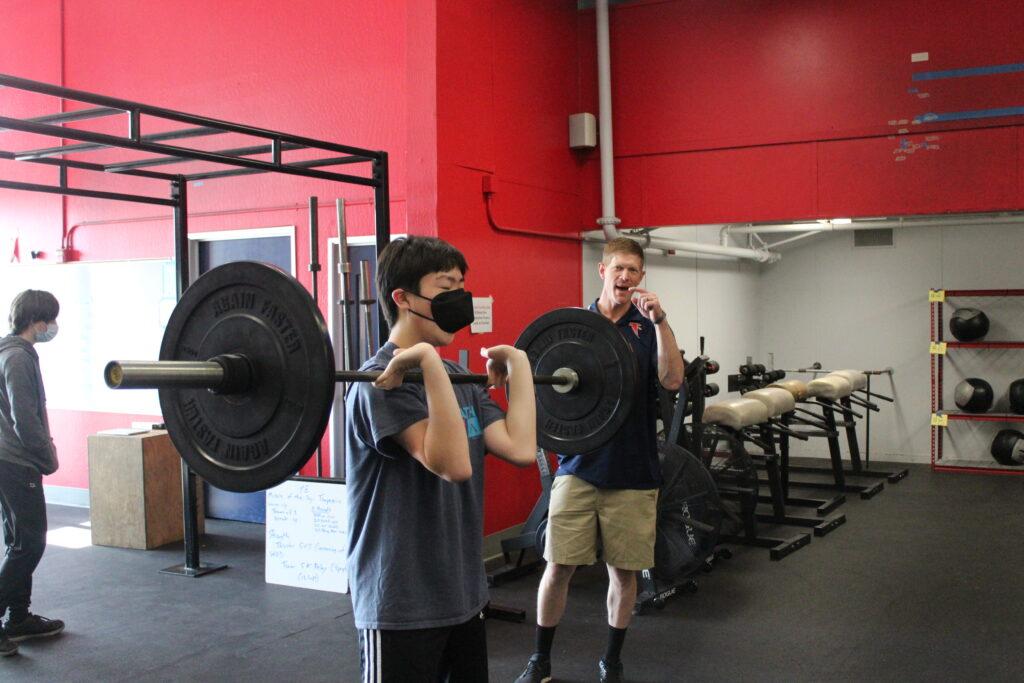 Kristofer Orre instructs junior Anthony Wang on proper form for an exercise called the thruster.