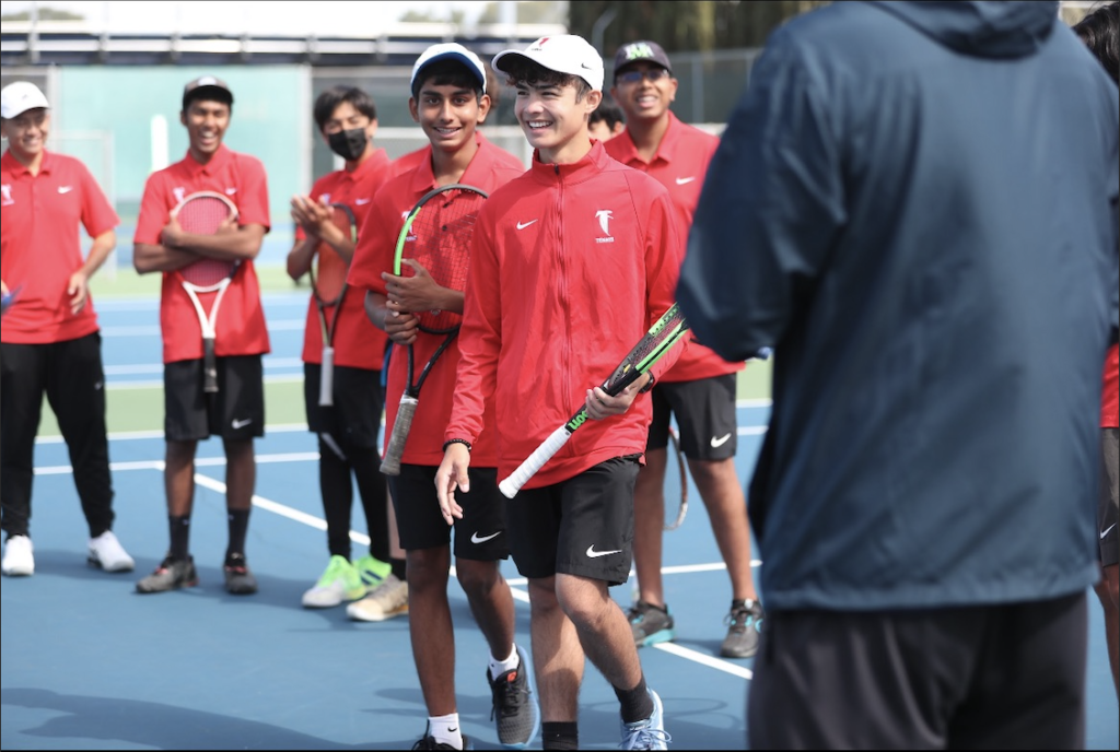 The boys’ tennis team discuss strategy and share a laugh prior to their match against Bellarmine