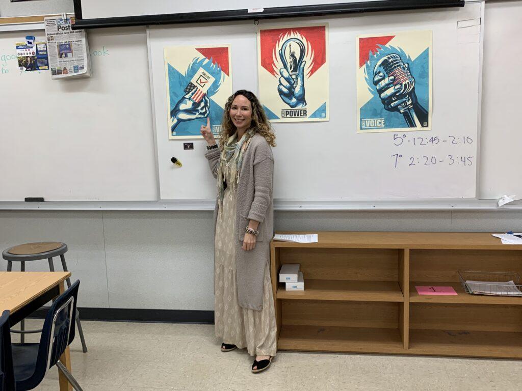 Gloriana Garcia standing in front of motivational posters in her room.