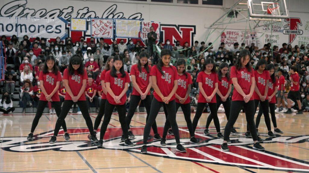 The dance team stands in their beginning position on Sept. 19 as they wait to begin performing at the first rally of the school year.