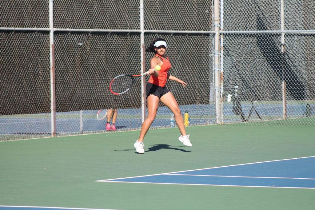 Sophomore Megha Horantur hits the ball at a tennis game.