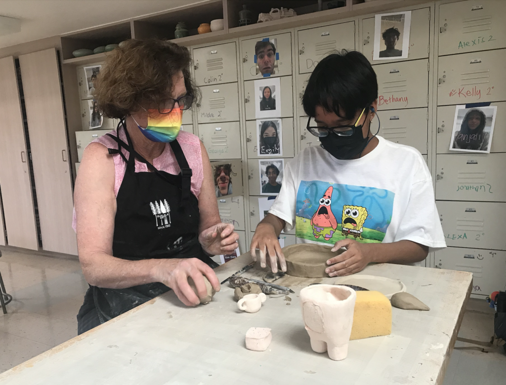 Ceramics and Media Arts teacher Theresa Muñoz assists a student molding clay into pottery in fourth period Ceramics 