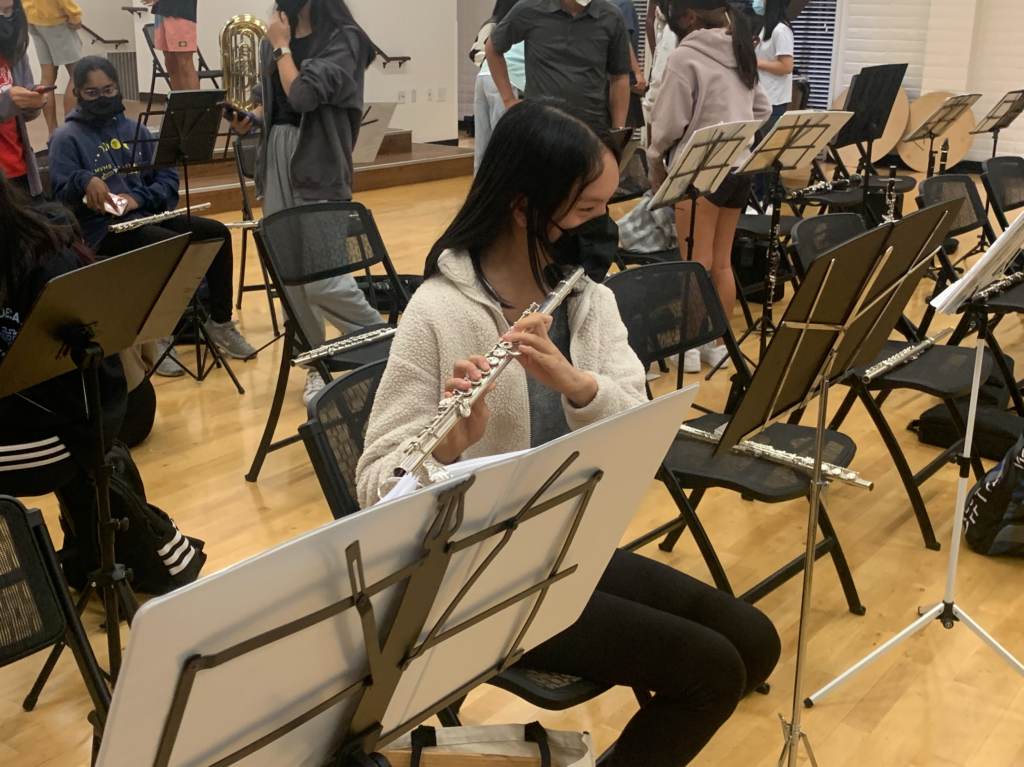 Junior Levana Lai practices her piece during break at orchestra rehearsal. 


