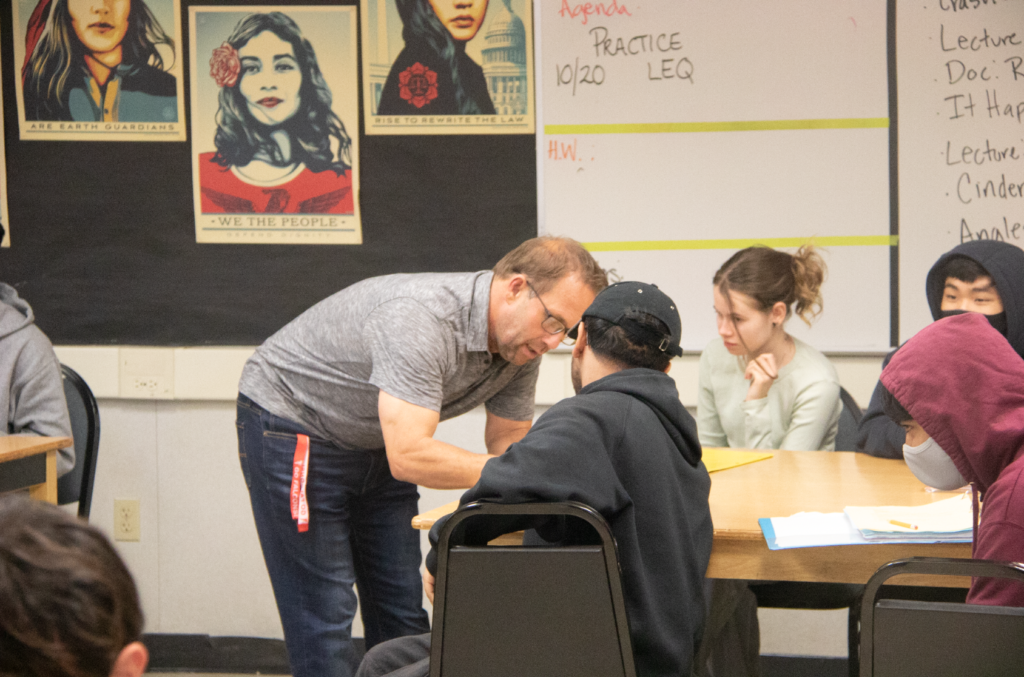 Substitute Chris Rasmussen, who teaches U.S. history and History in Film, works with a student during fourth period on Oct. 19.