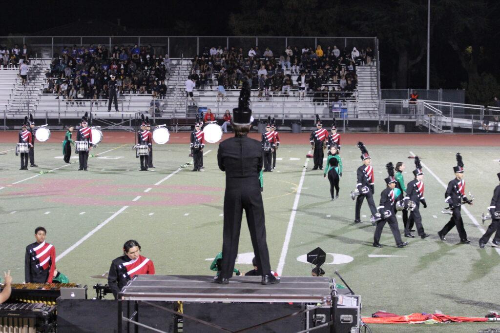 Drum Major Petr Tupitsyn overlooks his marching band, ready to showcase their senior night performance.