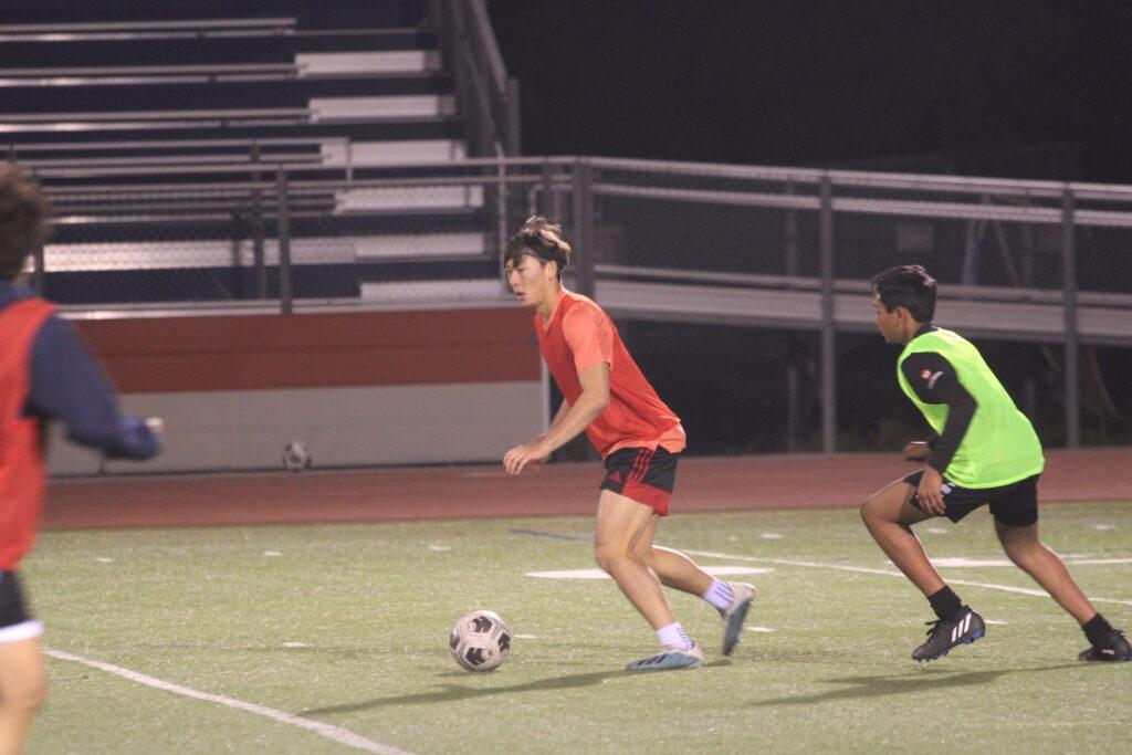 Senior captain Dylan Sinton dribbles the ball across the field during a Tuesday night practice match.