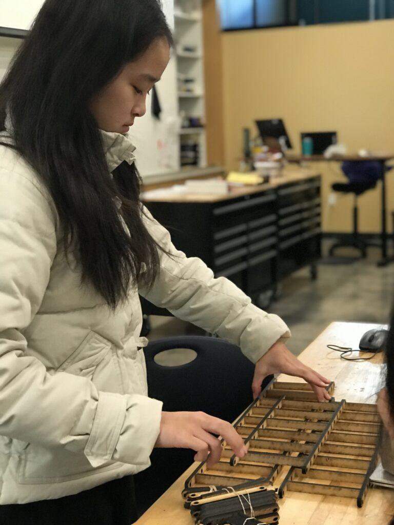 Sophomore Vera Fung assembles her laser-cut beams into each truss for her Principles of Engineering bridge project.