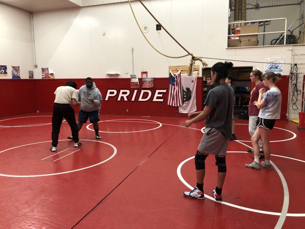  Coach Taylor Wilson and senior captain Sohum Bhan instruct a series of wrestling moves to the rest of the team.