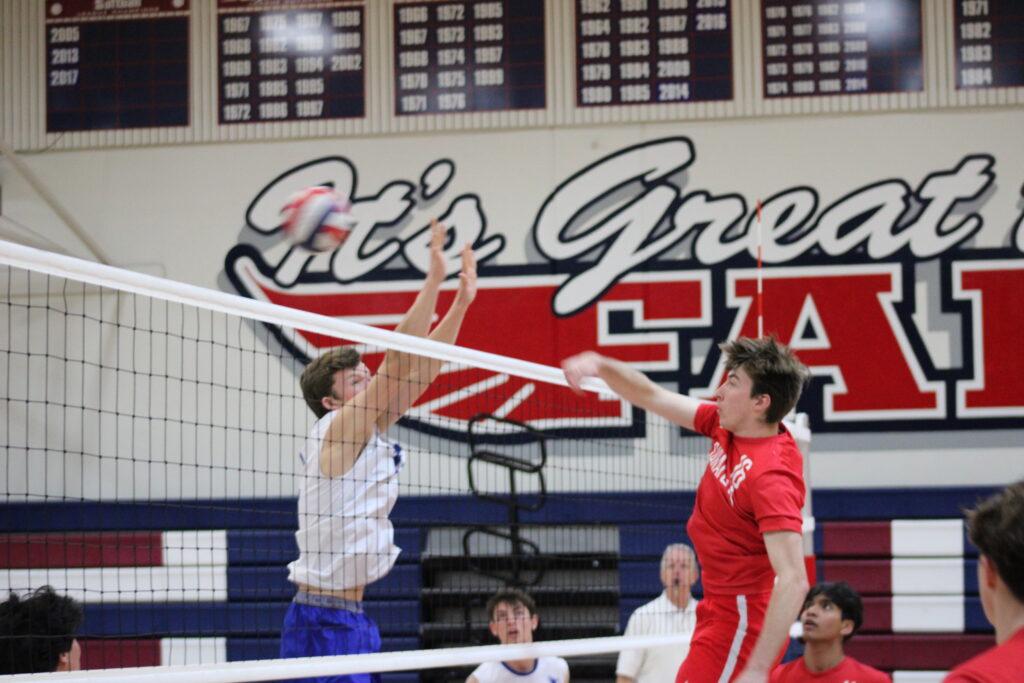 Senior middle Mateusz Palusinski spikes the ball past the opponents’ defense to score a point.