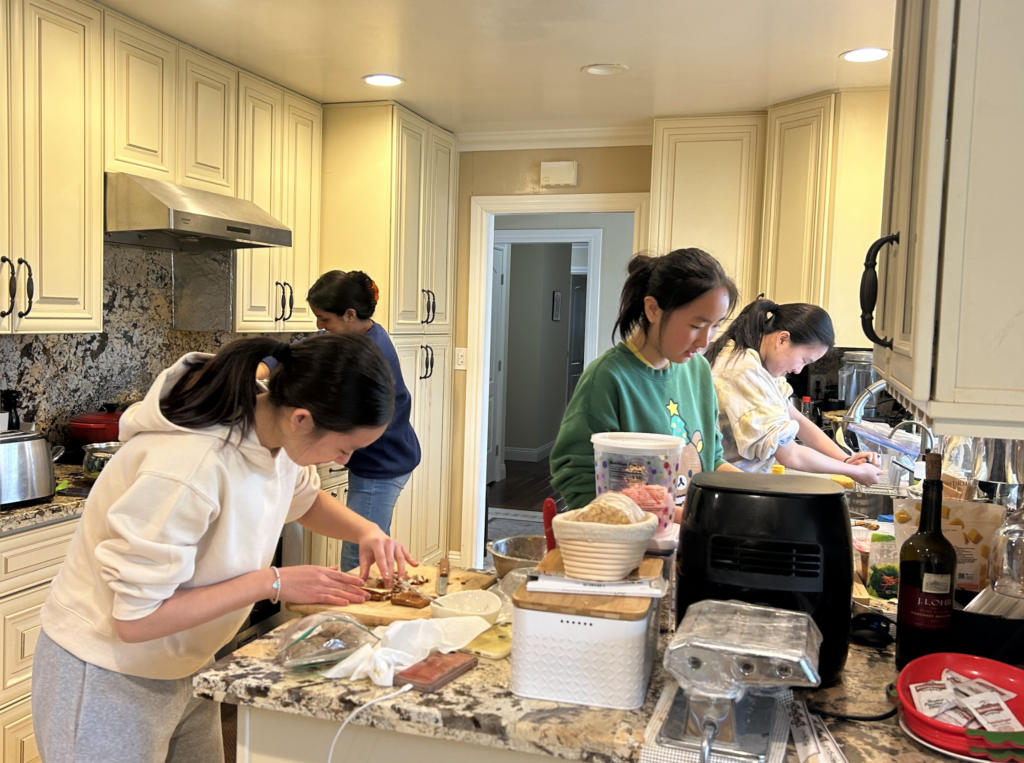 Sophomores Sunny Cao, Emma Fung, Saachi Jain and Kathy Wang work hard in the kitchen to prepare a feast.
