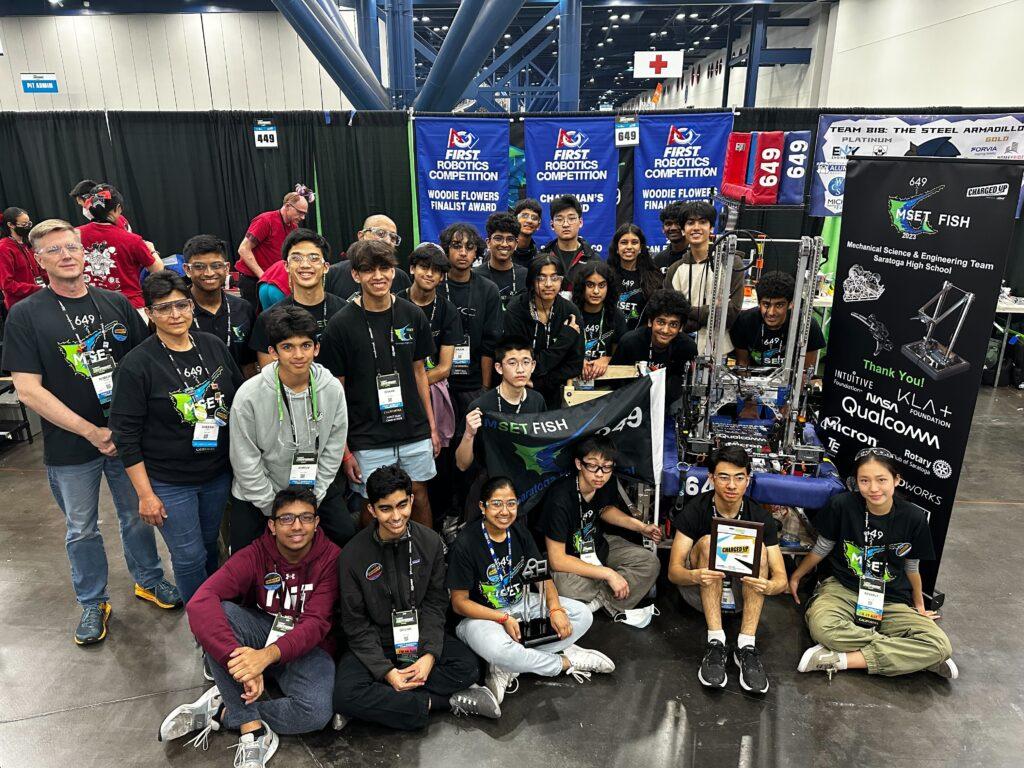 After their final match at the World Championship, the team gathers around their robot to take a team photo.
