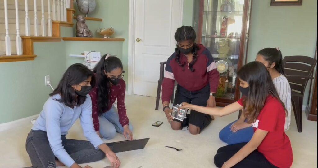 Sophomore Samanvi Boppana (center) and her team work on their CubeSat, a nanosatellite concept by NASA that can detect plastic in the ocean.