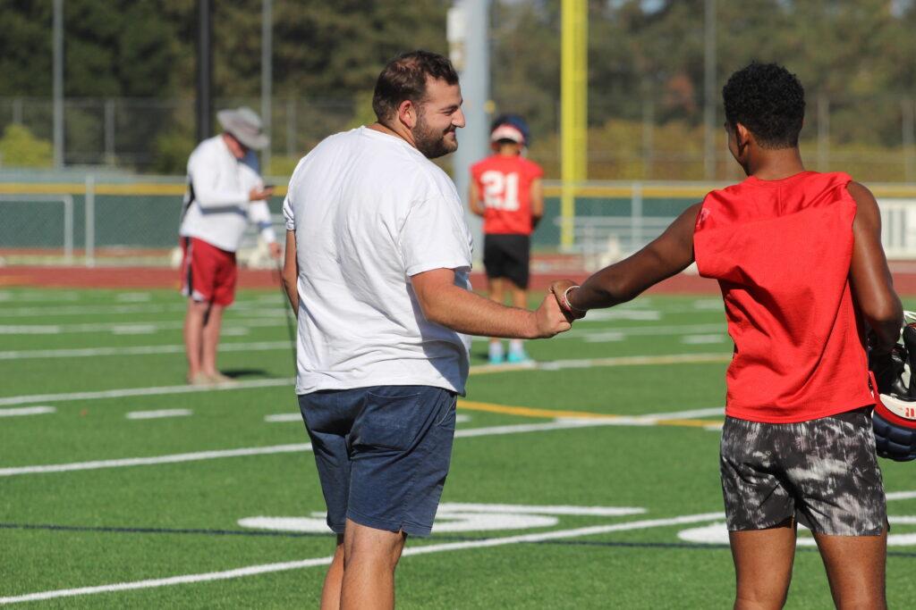 Andrew Beattie works with football players during an after school practice.
