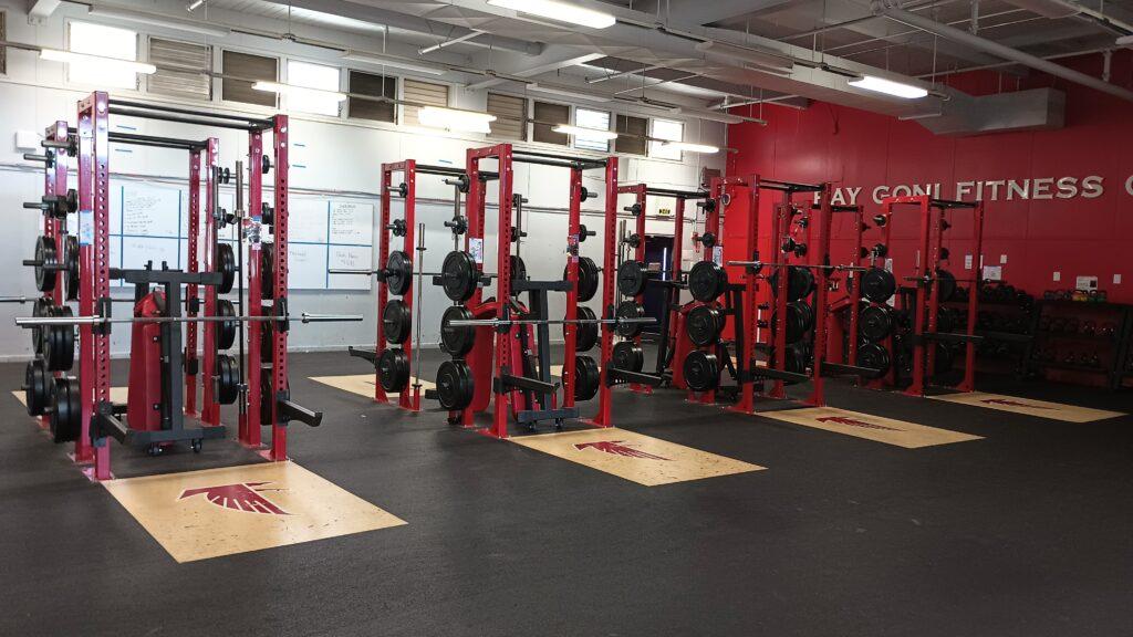 The weight room contains rows of benches and weight racks