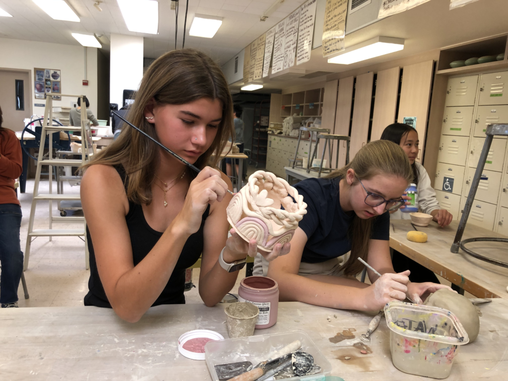 Sofia Hoffman and Elisa Pattullo work on glazing their decorative coil pot on Oct. 11.