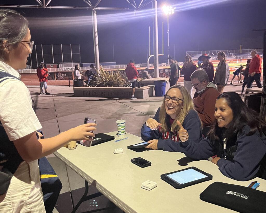 Teachers Seema Patel and Sarah Voorhees check a GoFan confirmation during a football game on Oct. 20.