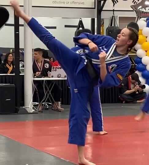 Senior Margaret Laver performs a roundhouse kick during her black belt assessment at the Sunnyvale Martial Arts Academy.