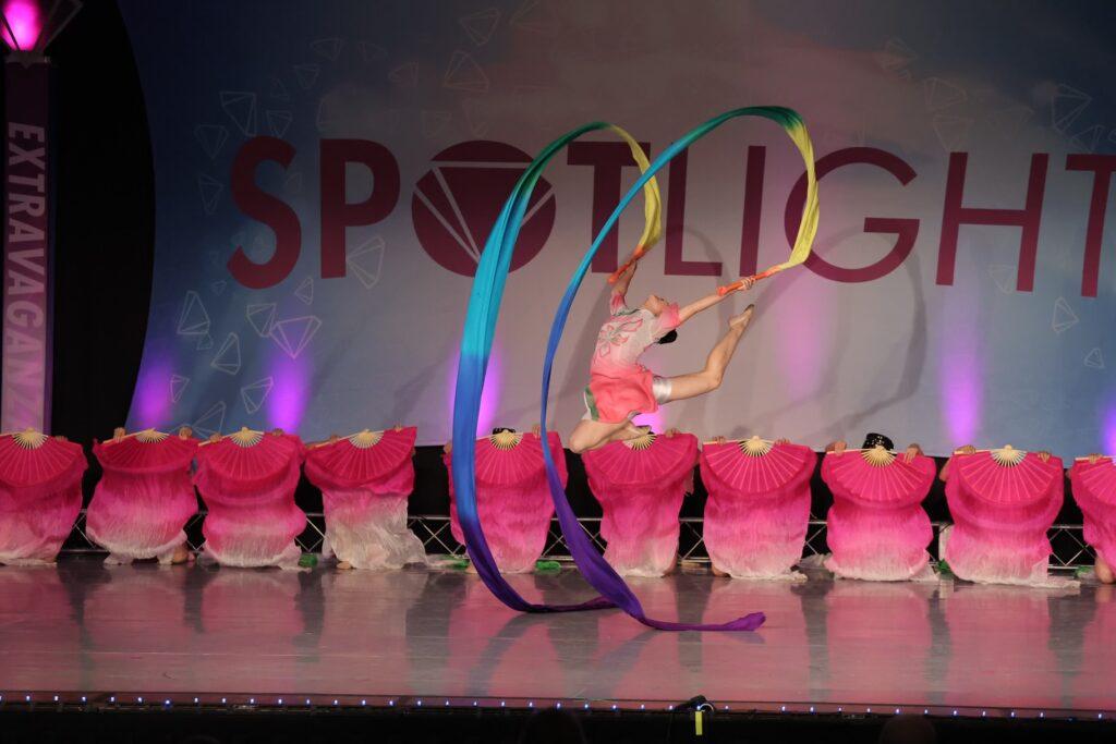 Ashley+Xu+does+a+double+stag+jump+while+holding+rainbow+ribbons+during+her+solo+section+of+the+folkloric+group+routine+%E2%80%9CColorful+Joy%E2%80%9D+during+the+performance+at+Spotlight+Dance+Cup+nationals+on+July+8.