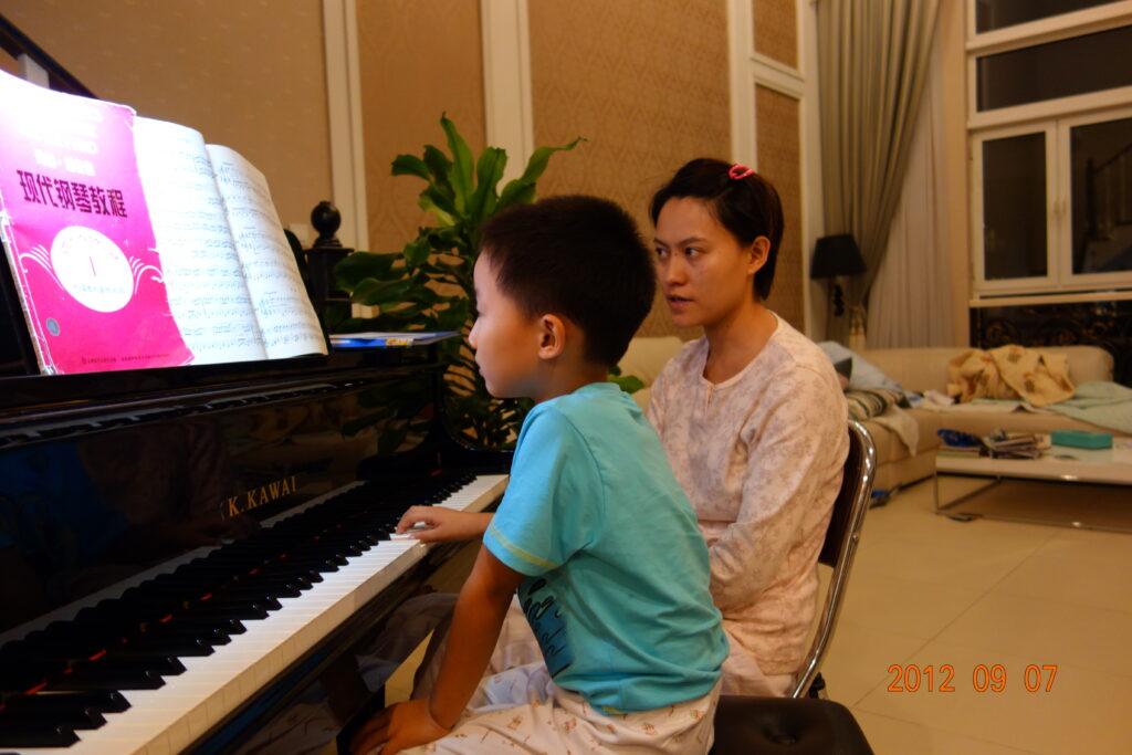 A nostalgic photo of my mother teaching me piano in 2012, when I was five years old. 