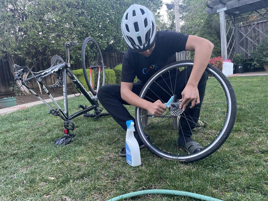 Freshman Dylan Zuo takes the rear wheel off to clean a bike’s cassette.