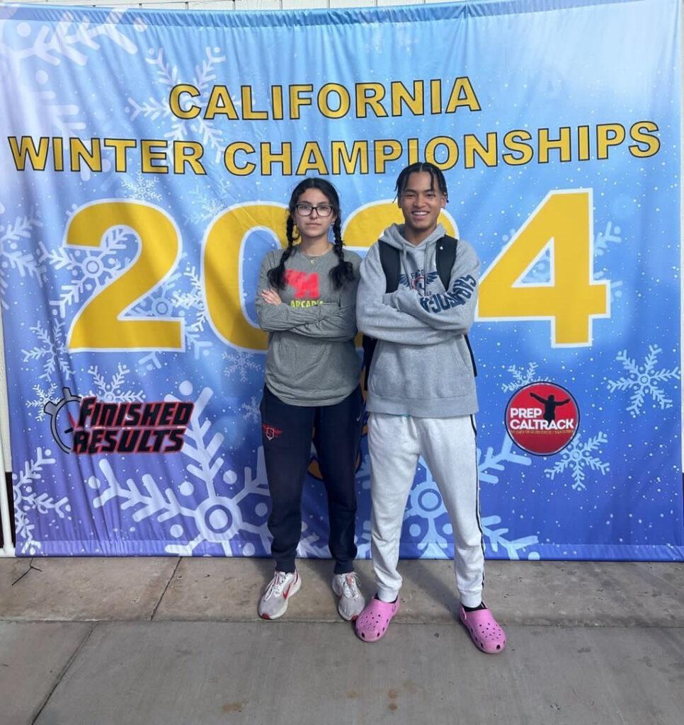 Juniors Dylan Wilson and Natalie Zaragoza posing in front of a banner after the California Winter Track and Field Championships at Arcadia High on Feb. 3.