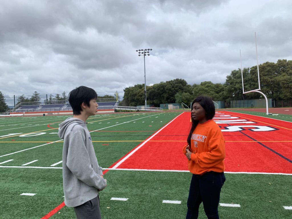 Coach Osayi Omorodion gives sprinting suggestions to sophomore Steven Sun.