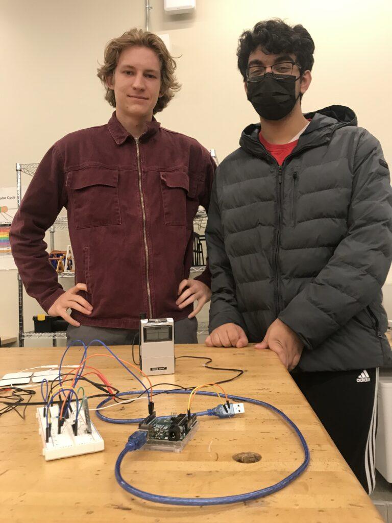 Seniors Eric Norris (left) and Shreyash Das Sharma (right) stand with their stimulus pad project, which creates the feeling of resistance in conjunction with the new Apple Vision Pro. 
