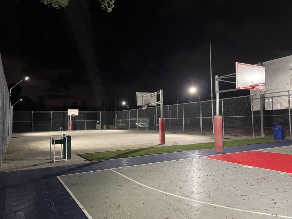 The+outdoor+basketball+court+without+flooring+at+night.