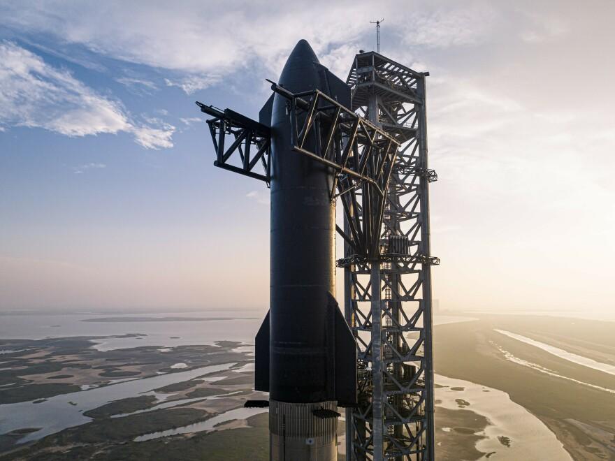 The third testflight of the Starship ready on the launch tower on March 14, displaying the black-covered Starship prototype atop the silver Super Heavy Booster.