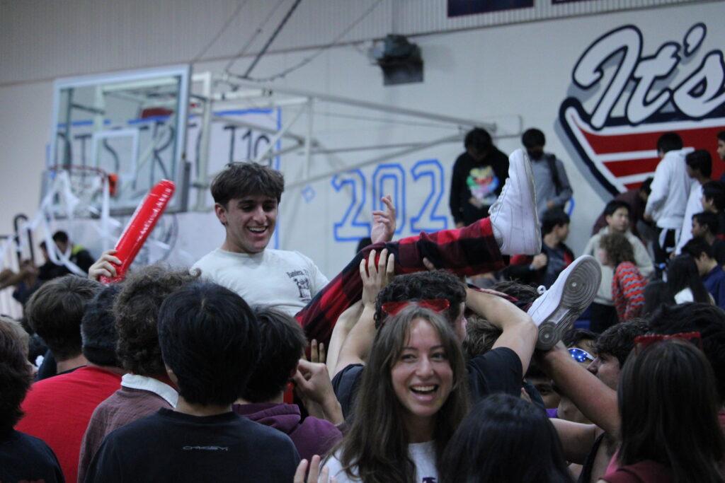 Senior Omead Bagherian crowd surfs in the seniors following the popping of the balloons.