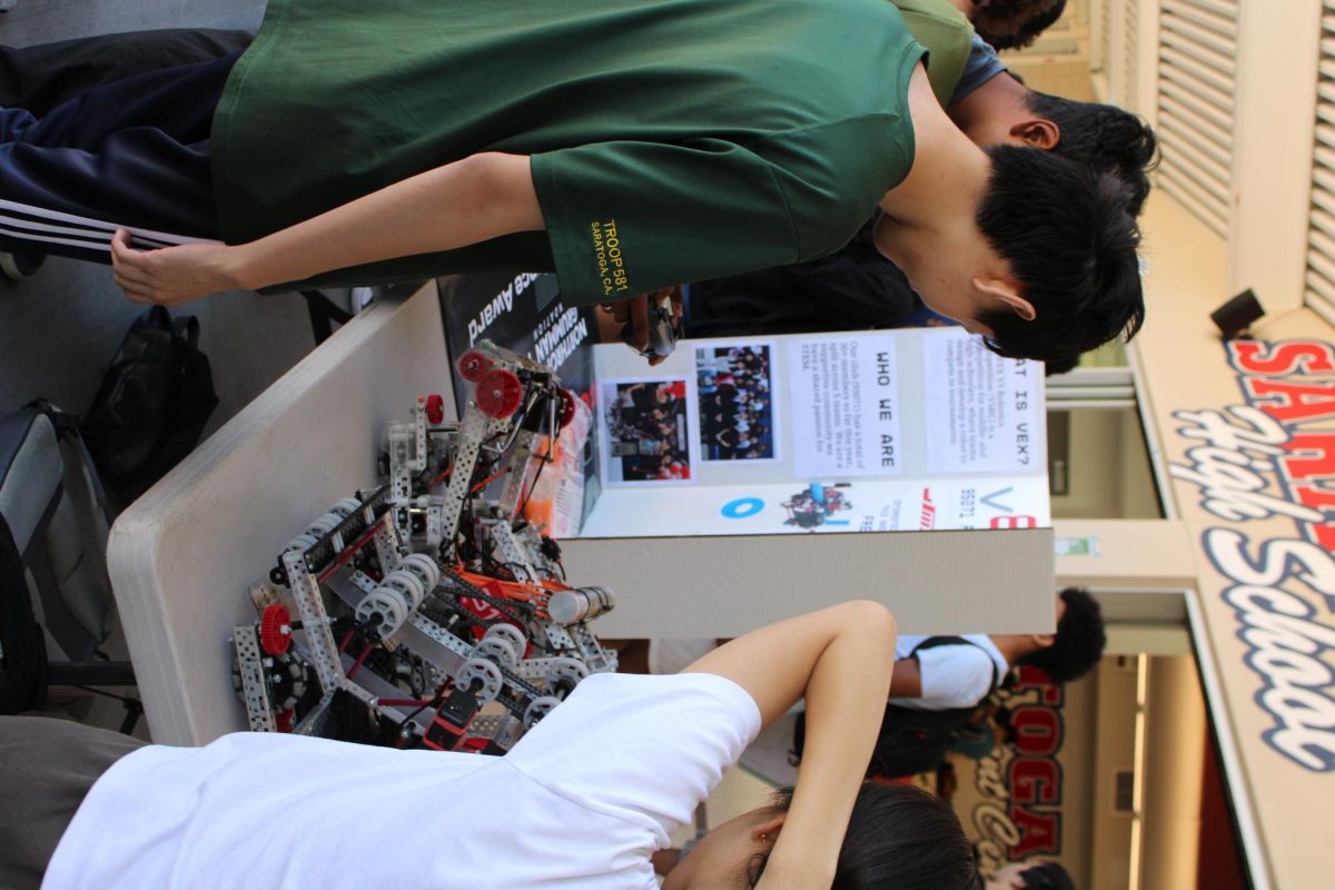 Senior VEX member Luke Zhang showcases the robots to students.