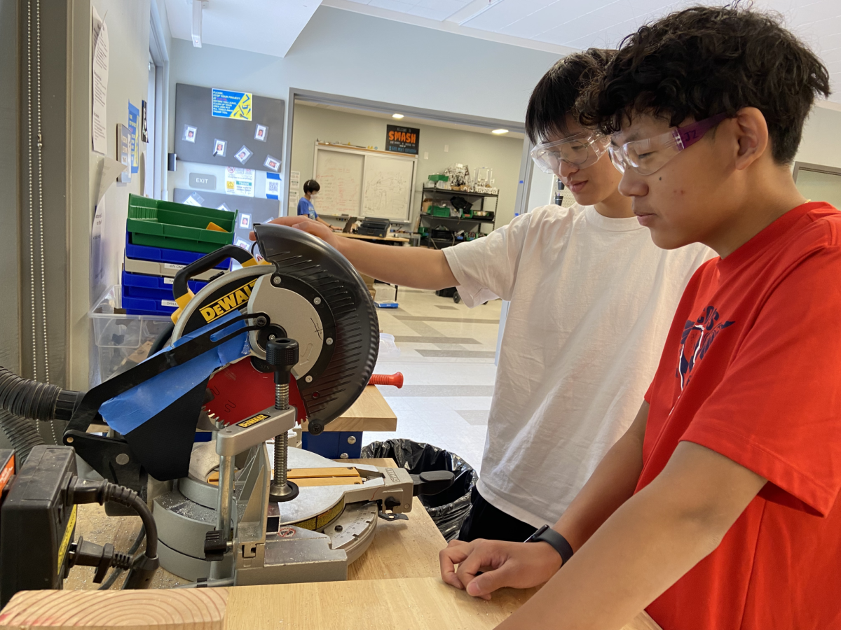 Sophomore David Huan and senior Jamar Zhou cut a piece of metal on the hacksaw.