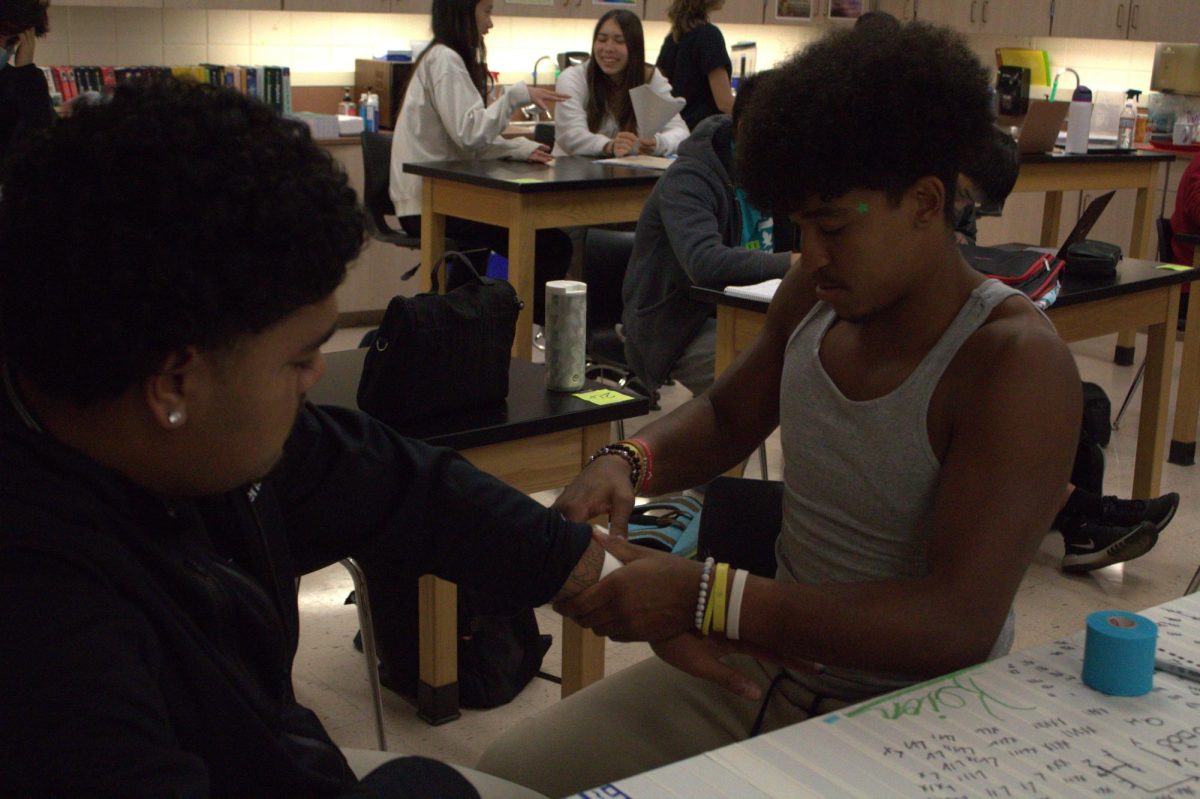 Seniors Keion Ashjaee-Marshall and Tevita Pahulu practice taping wrist injuries.
