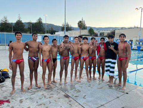 Team poses for team photo next to pool deck