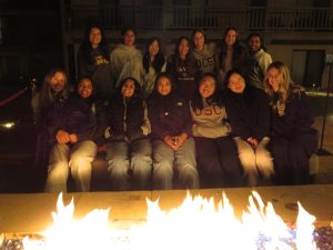 The team gathered around a fire during their retreat to enjoy s’mores and build team chemistry.