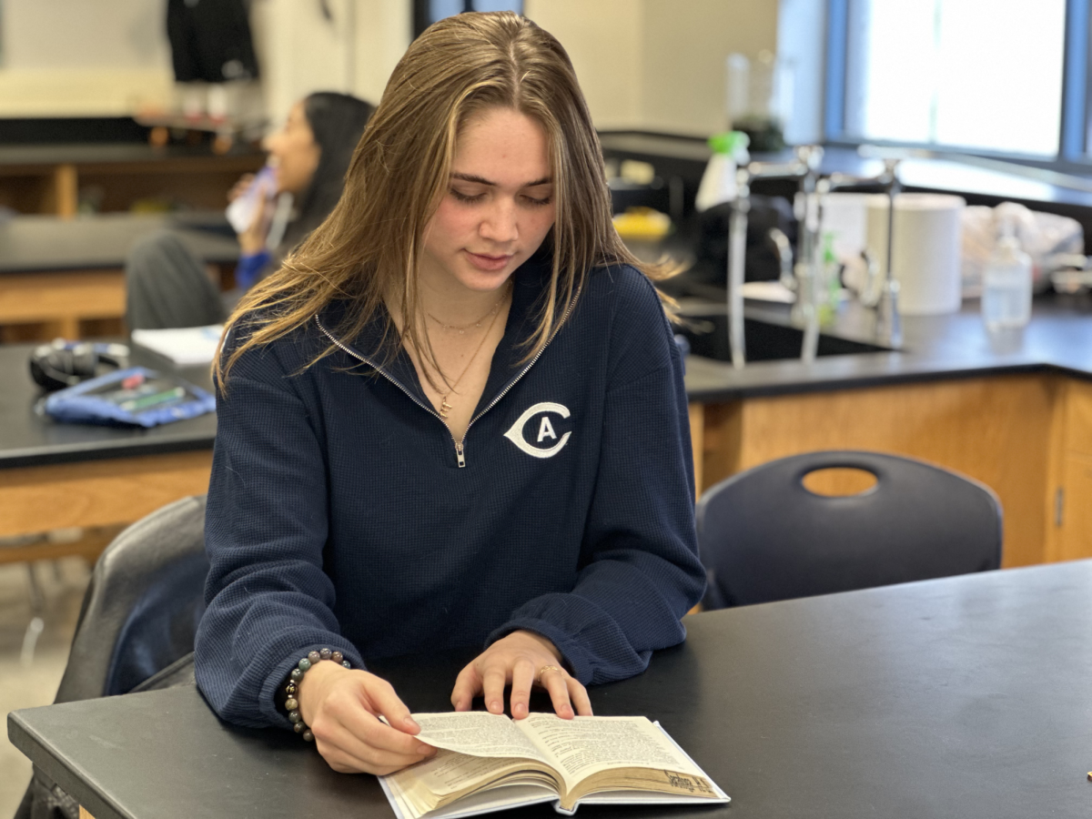 Junior Elizabeth Kline reading her English book.