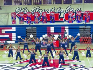 Members of the dance team hold a pose in their competition pom routine, performing at the girls’ basketball game on Jan. 17.