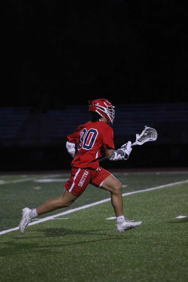 Brennan runs with the ball in a lacrosse game last season against Gunn.